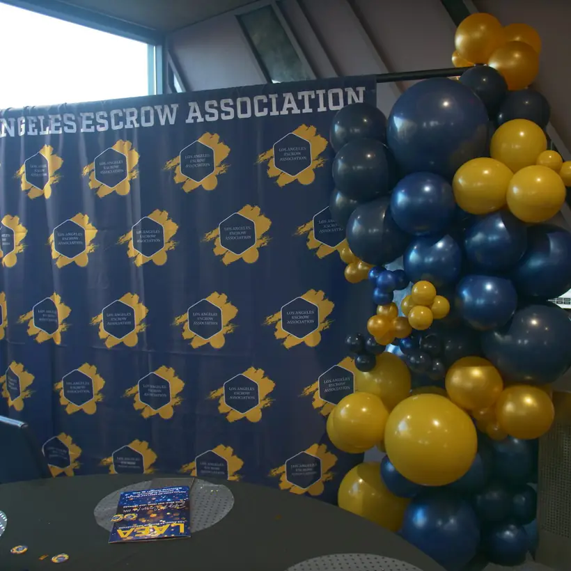 LAEA Sneaker Ball backdrop with blue and gold balloons